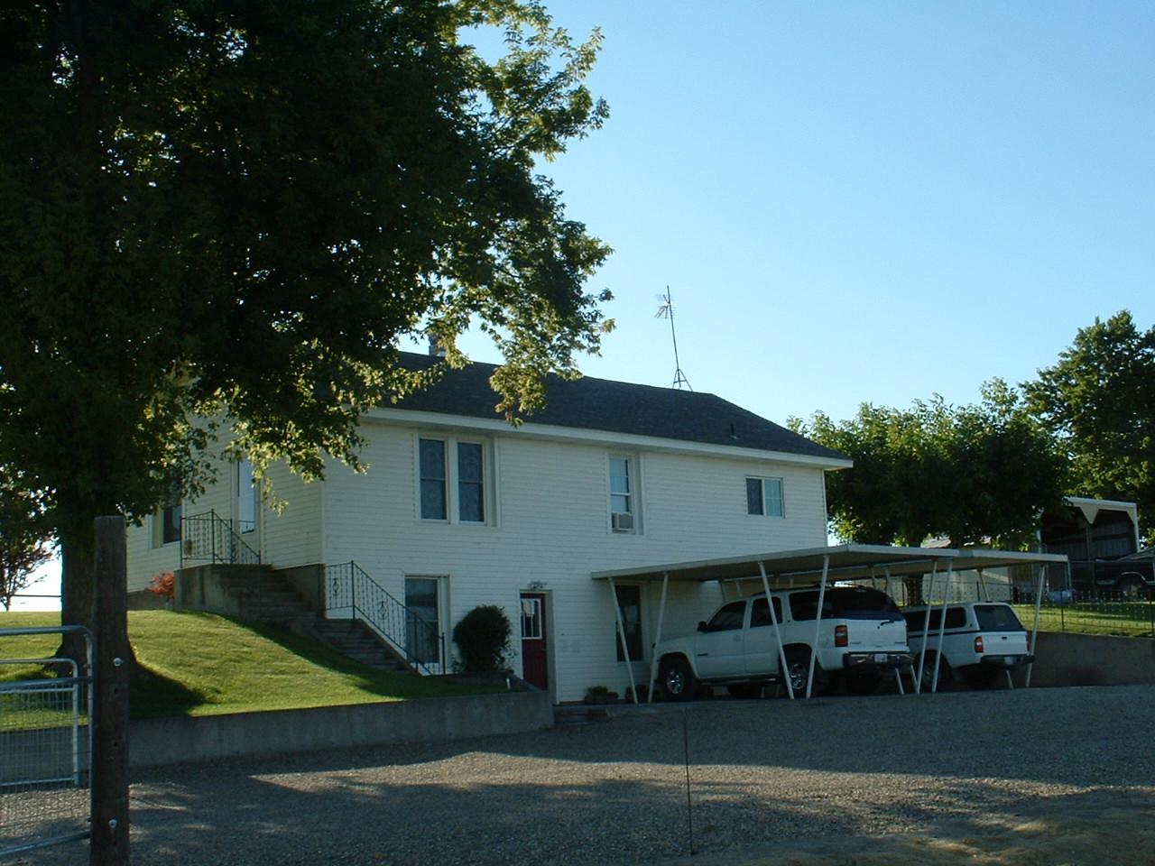 41 Knowles Road Outlook, WA 98938 - Photo 2 of 10 a view of a white house next to a yard with plants and trees
