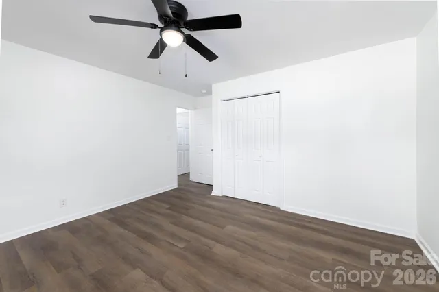 an empty room with a ceiling fan and a window