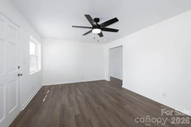 a view of a room with wooden floor and a ceiling fan