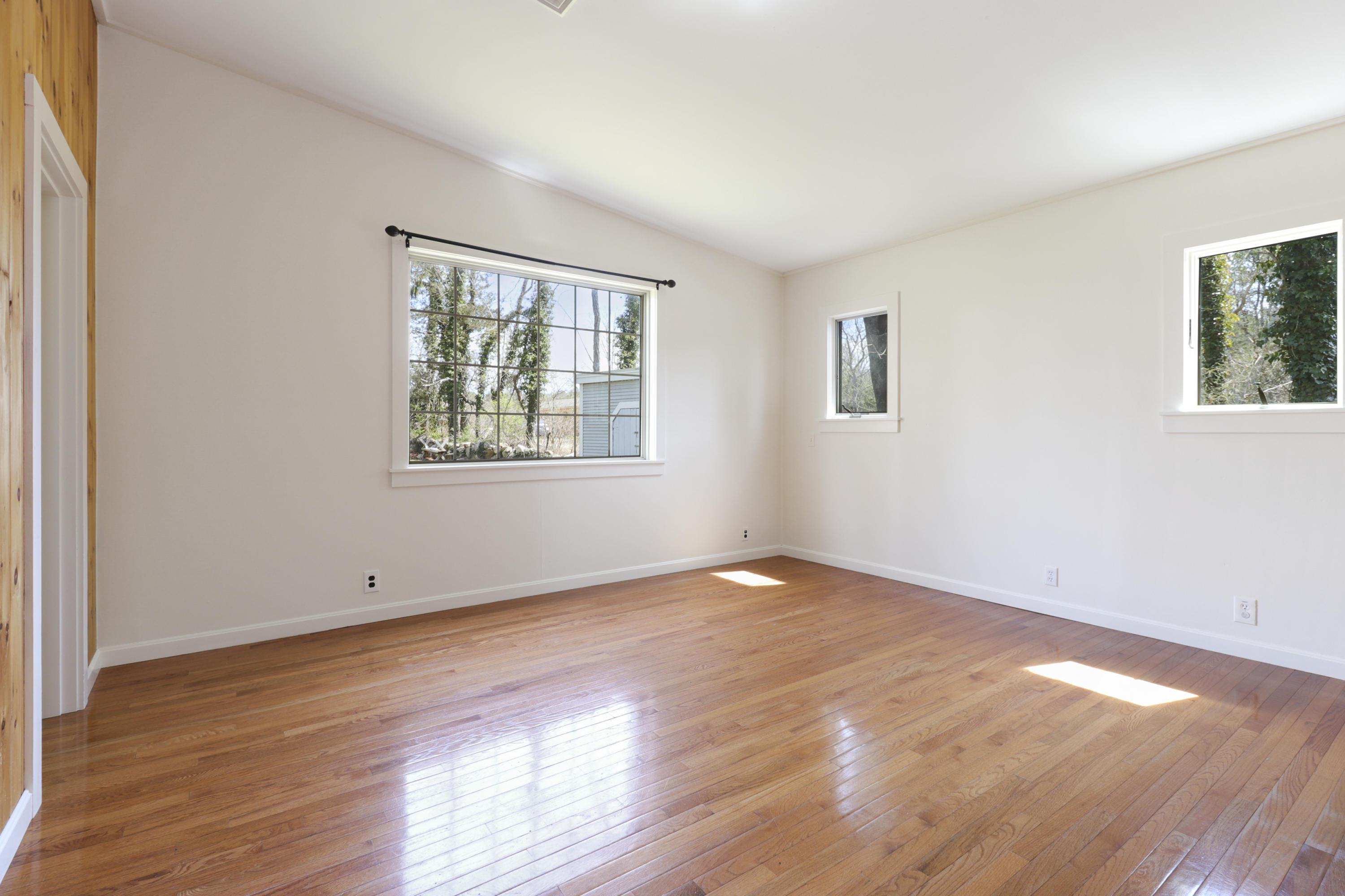 1245 A County Road Cataumet, MA 02534 - Photo 7 of 23 a view of an empty room with wooden floor and a window