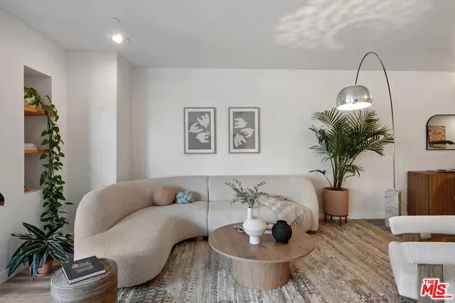 a living room with furniture flowerpot and wooden floor