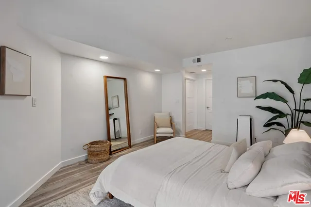 a bedroom with a bed and a painting on the wall