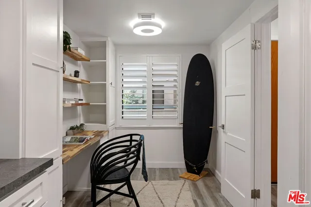 a view of a workspace with furniture and a window