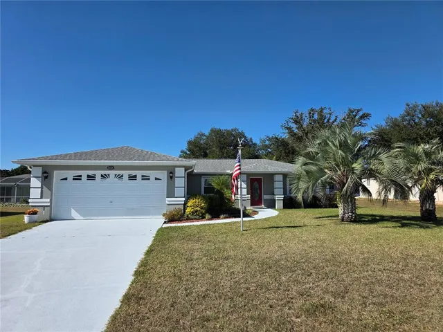 a front view of house with yard and trees around