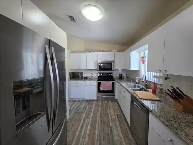 a bathroom with a granite countertop sink a mirror and shower