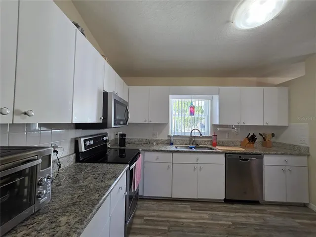 a bathroom with a granite countertop sink a mirror and shower
