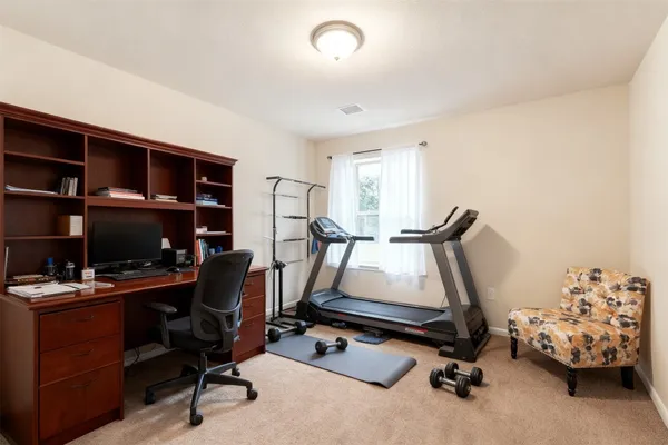 a view of a workspace with furniture and a window