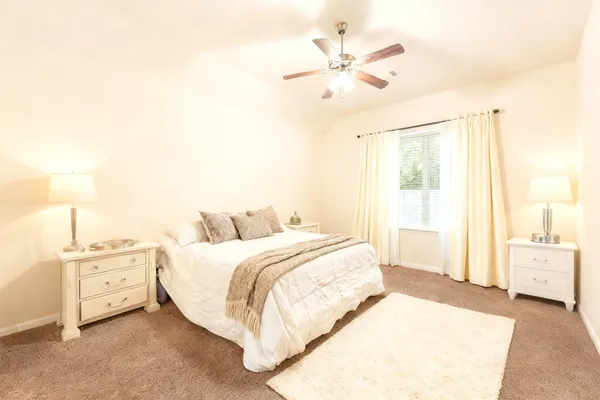 a spacious bedroom with a bed and a chandelier