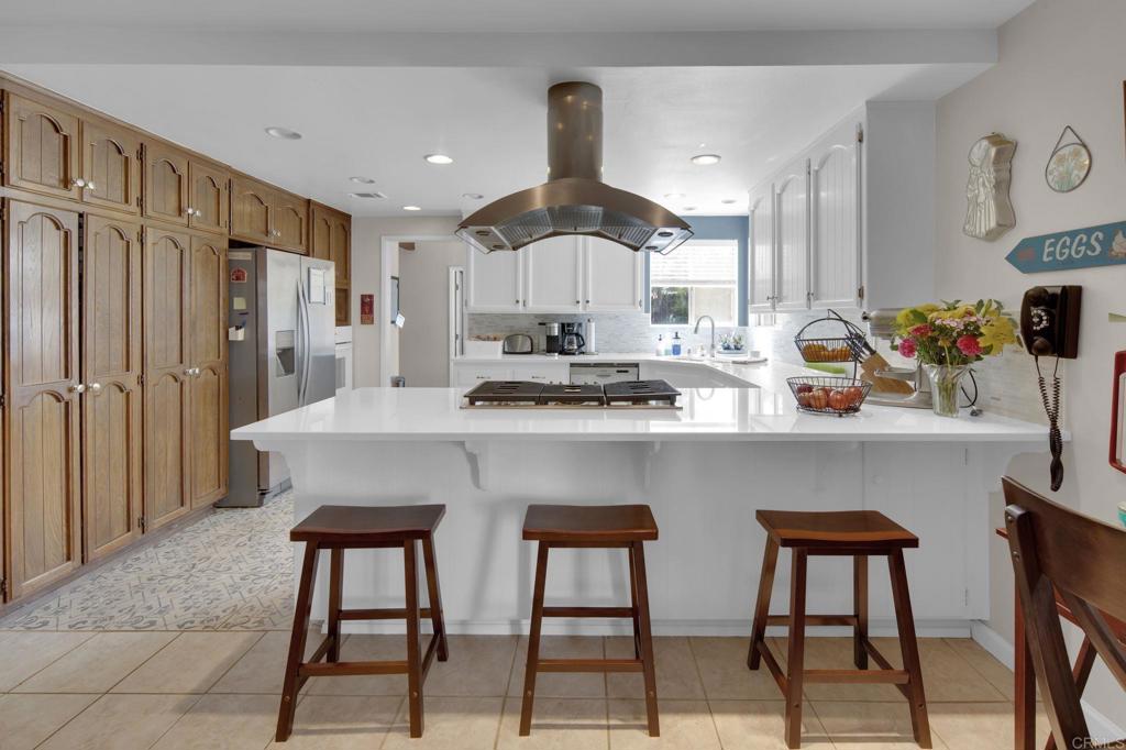30010 Miller Road Valley Center, CA 92082 - Photo 1 of 1 a kitchen with stainless steel appliances a dining table chairs and a refrigerator