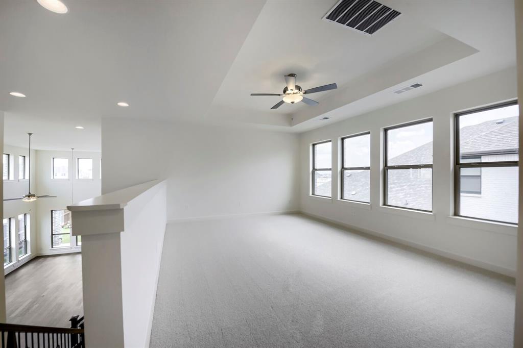 11548 Wulstone Road Haslet, TX 76052 - Photo 11 of 26 Spacious upper-level area featuring a tray ceiling with a ceiling fan and recessed lighting, multiple windows, and light-toned carpeting