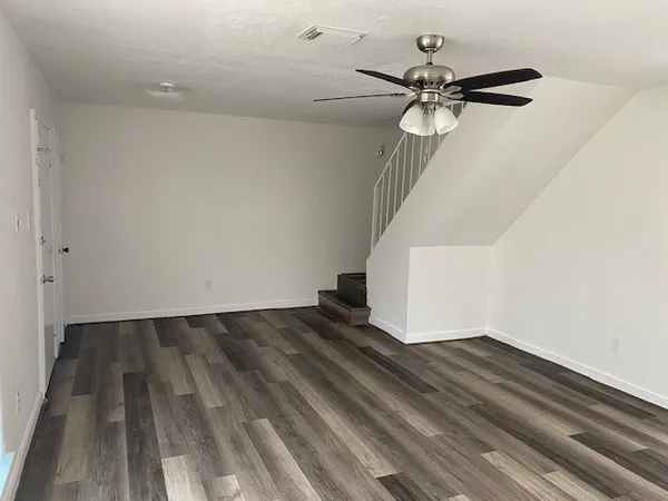 a view of a room with wooden floor and staircase