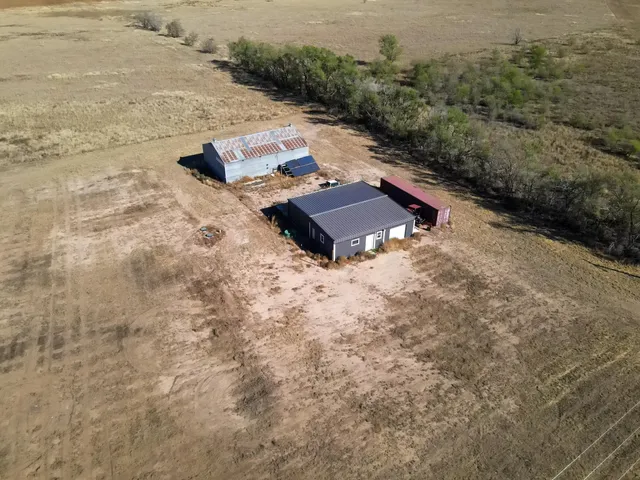 an aerial view of a house with yard and mountain view in back