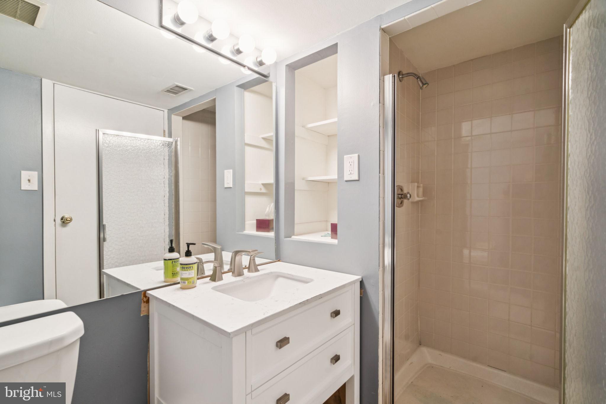 115 Cuthbert Street, Unit B Philadelphia, PA 19106 - Photo 7 of 30 a bathroom with a sink a mirror and a shower