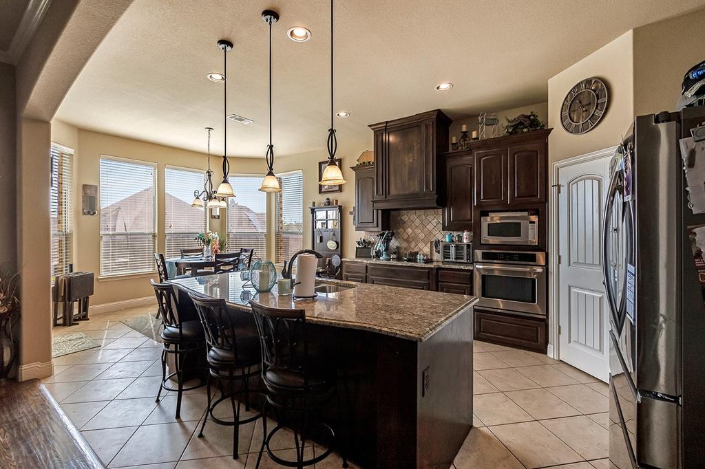 3206 Meadow Ridge Drive Midlothian, TX 76065 - Photo 24 of 37 a kitchen with stainless steel appliances granite countertop a refrigerator a sink a stove and a wooden floors