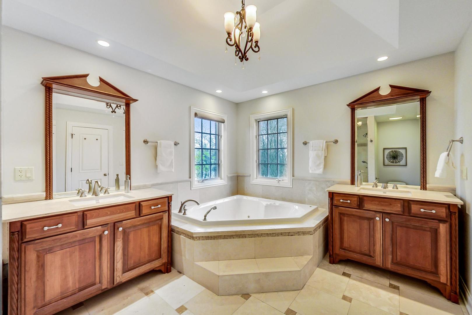 2027 Maple Avenue Northbrook, IL 60062 - Photo 13 of 27 a spacious bathroom with a tub sink and mirror