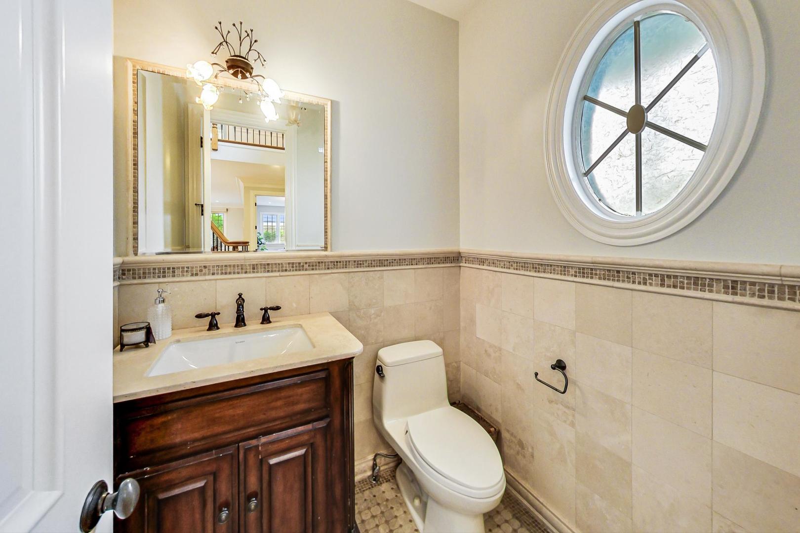 2027 Maple Avenue Northbrook, IL 60062 - Photo 10 of 27 a bathroom with a toilet a sink and a mirror