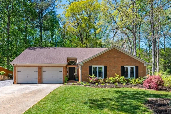 a front view of a house with a garden and yard