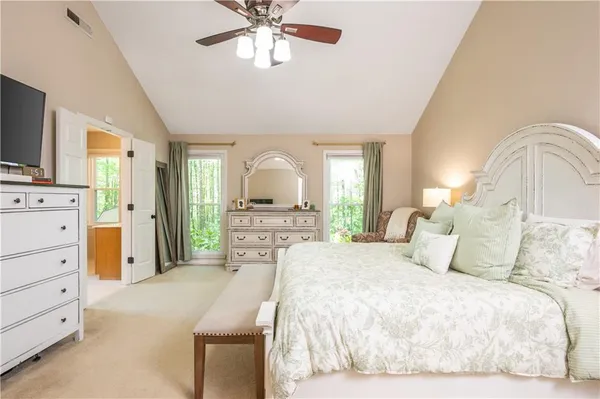 a bedroom with a large bed and a chandelier