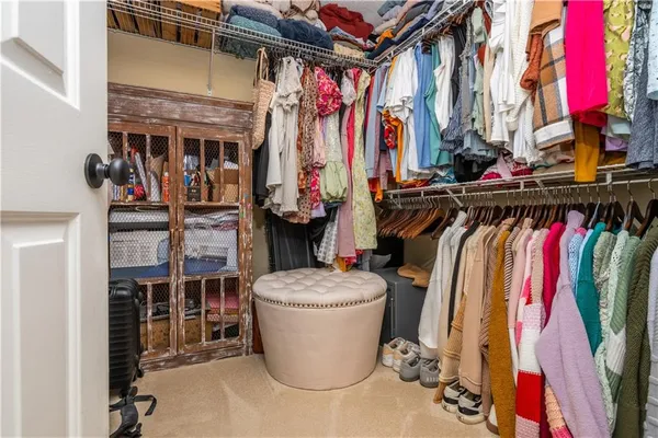 a view of walk in closet with clothes and shoes