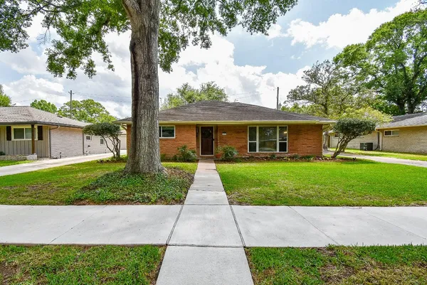 a front view of a house with a yard and trees