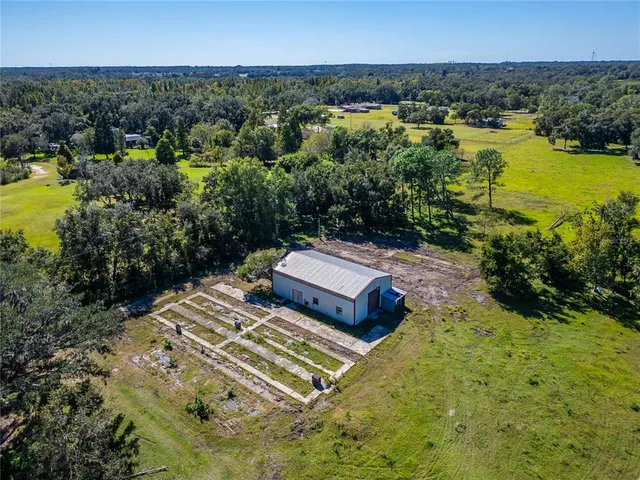 an aerial view of a house with a yard and lake view