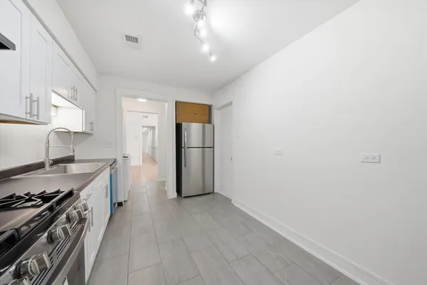 a kitchen with refrigerator and cabinets