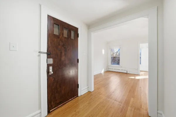a view of empty room with wooden floor