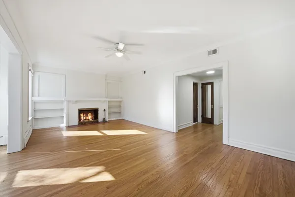 a view of a livingroom with wooden floor and a fireplace