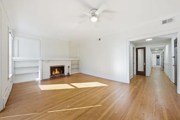 a view of a livingroom with wooden floor and a fireplace