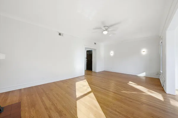 a view of an empty room and a ceiling fan