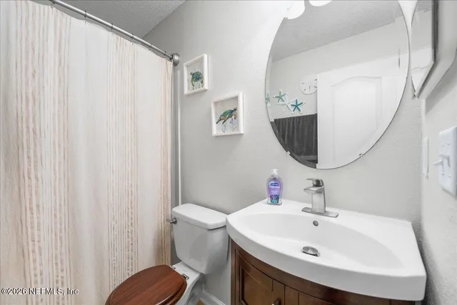 a bathroom with a sink toilet and a mirror