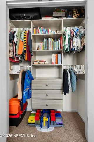 a view of walk in closet with clothes and shoes