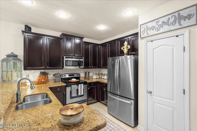 a kitchen with stainless steel appliances granite countertop a refrigerator sink and stove