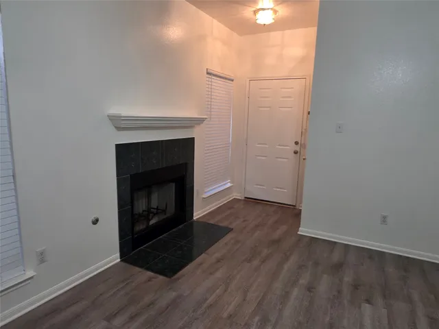 a view of a room with wooden floor and a fireplace