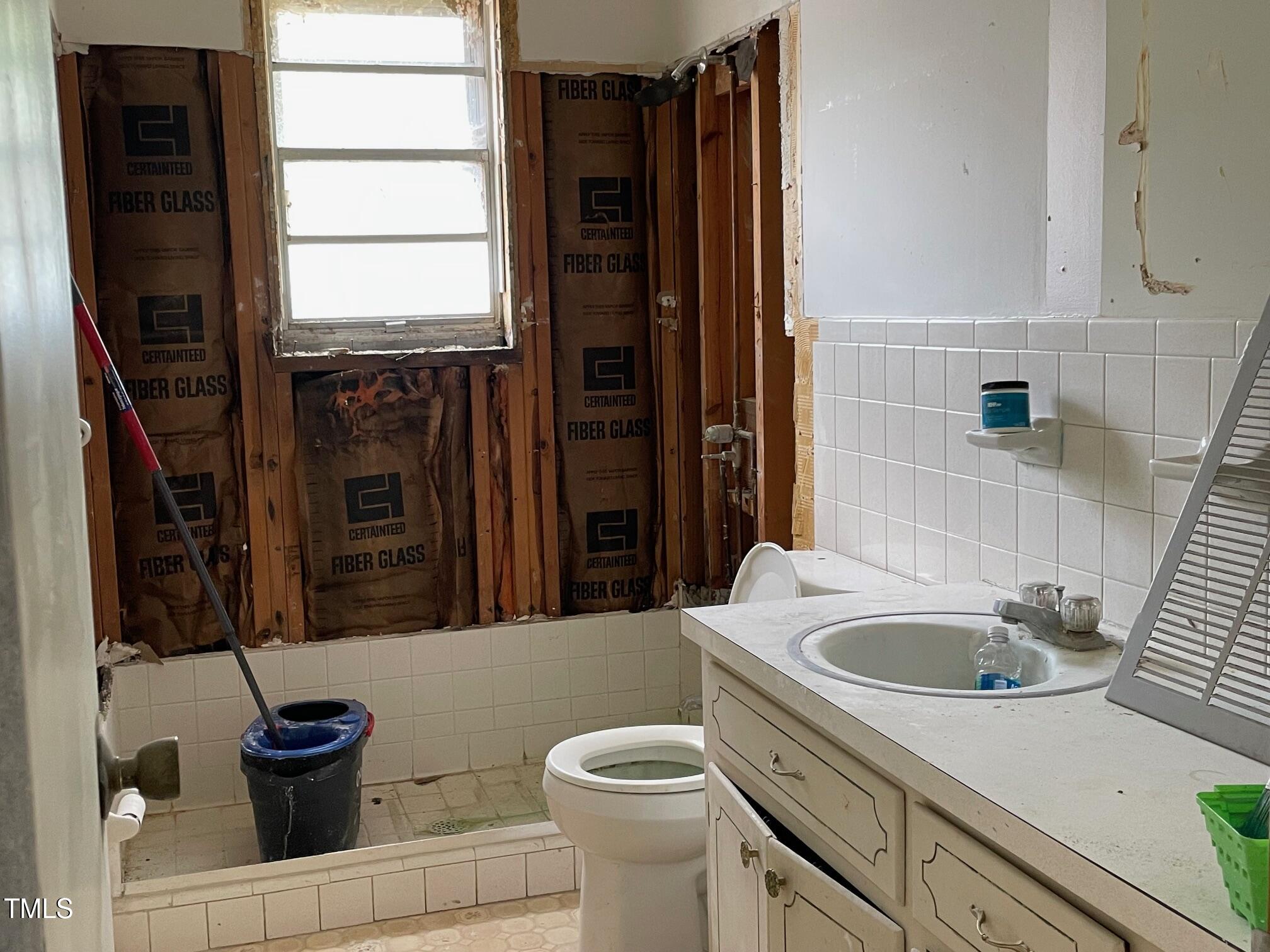 3311 Redwood Road Durham, NC 27704 - Photo 19 of 32 a bathroom with a sink a toilet and a shower