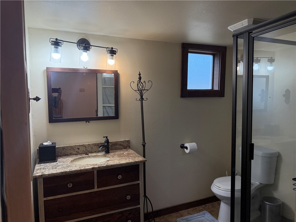 601 East 30th Street, Unit B Bryan, TX 77803 - Photo 9 of 15 a bathroom with a granite countertop toilet sink and mirror