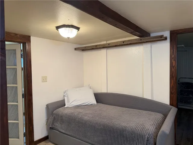 a bedroom with a bed and a flat tv screen on dresser