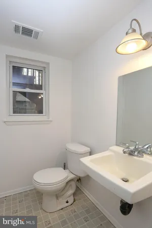 a bathroom with a toilet a sink and mirror