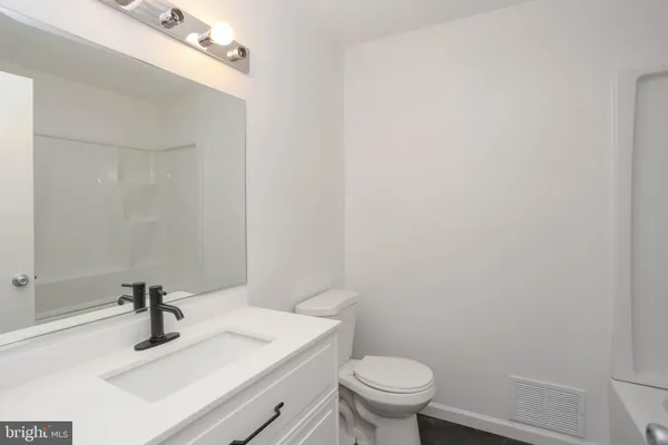 a bathroom with a sink a toilet and mirror