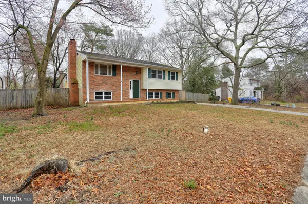 a view of a house with a yard and large trees