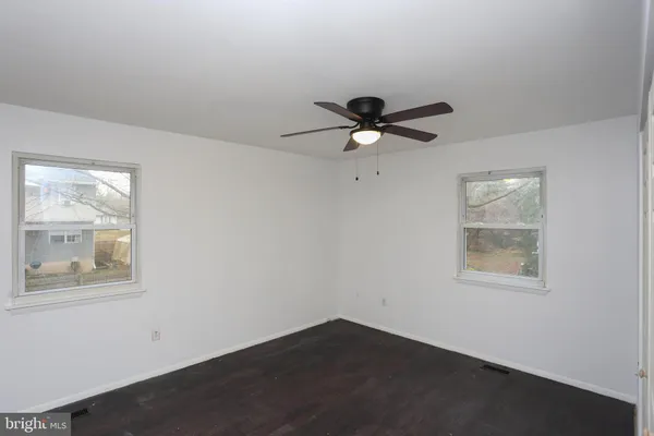 an empty room with window and ceiling fan