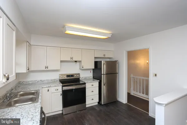 a kitchen with a refrigerator a stove a microwave and cabinets