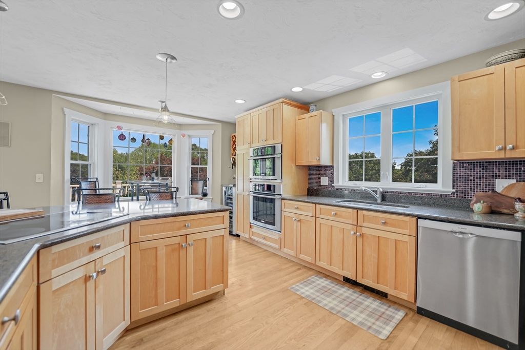 57 Perry Hill Road Acushnet, MA 02743 - Photo 17 of 40 a large kitchen with stainless steel appliances granite countertop a lot of counter space and wooden floors