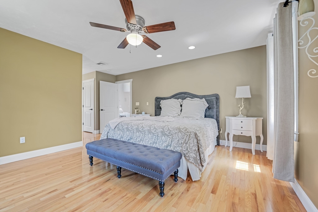 57 Perry Hill Road Acushnet, MA 02743 - Photo 23 of 40 a spacious bedroom with a bed and a chandelier