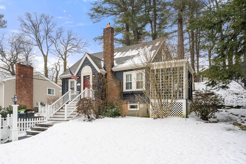 a front view of a house with a yard covered with snow in front of house