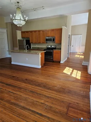 a view of a kitchen with cabinets stainless steel appliances and wooden floor