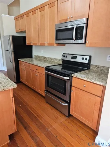 a kitchen with stainless steel appliances granite countertop a stove microwave and refrigerator