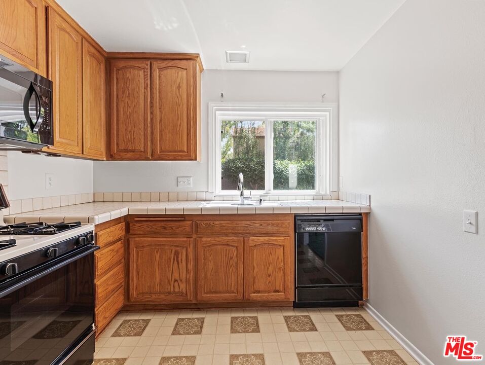 106 Sequoia Tree Lane Irvine, CA 92612 - Photo 7 of 36 a kitchen with stainless steel appliances granite countertop a stove a sink and a microwave