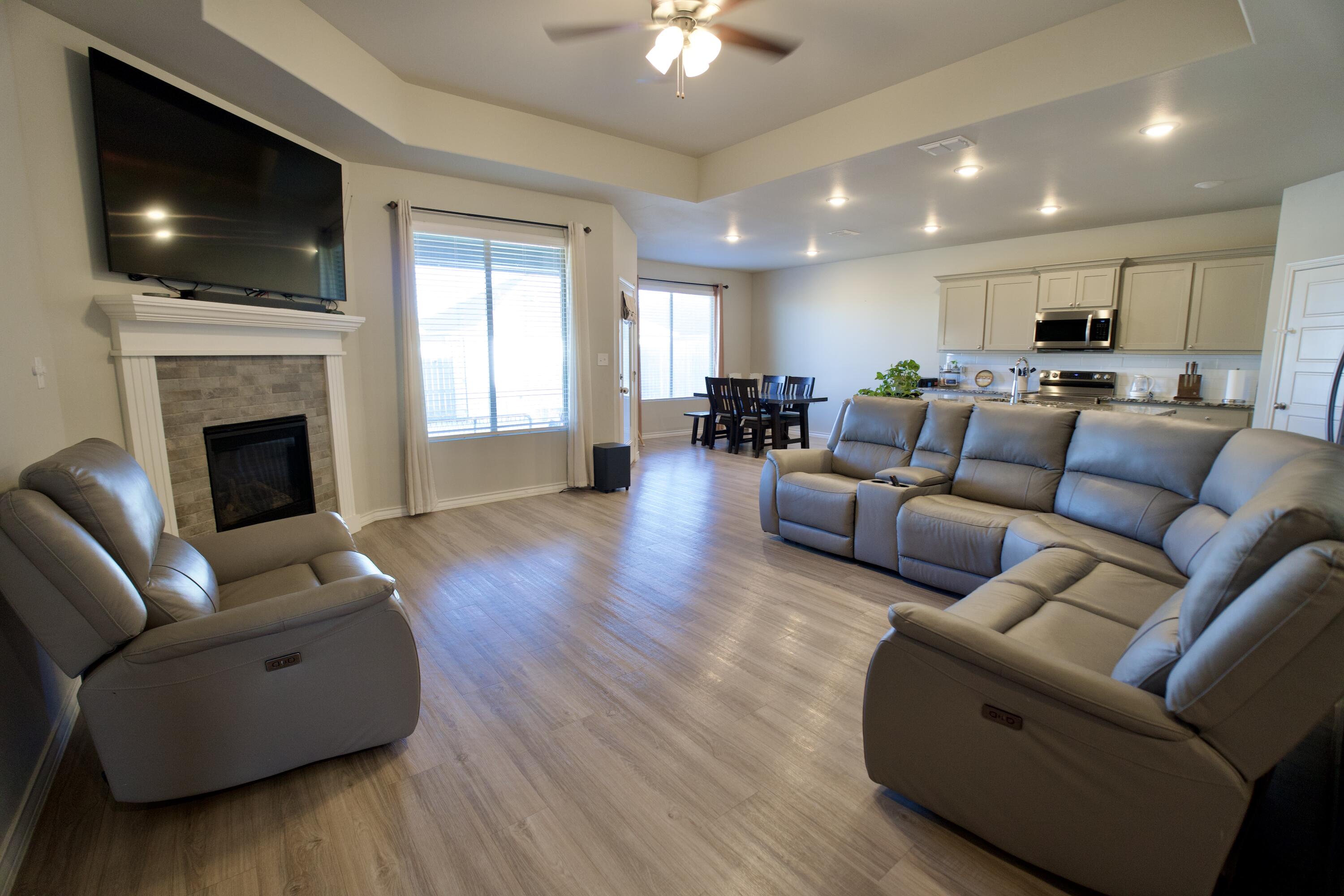 5801 Winfield Avenue Lubbock, TX 79407 - Photo 2 of 20 a living room with furniture a fireplace and a flat screen tv