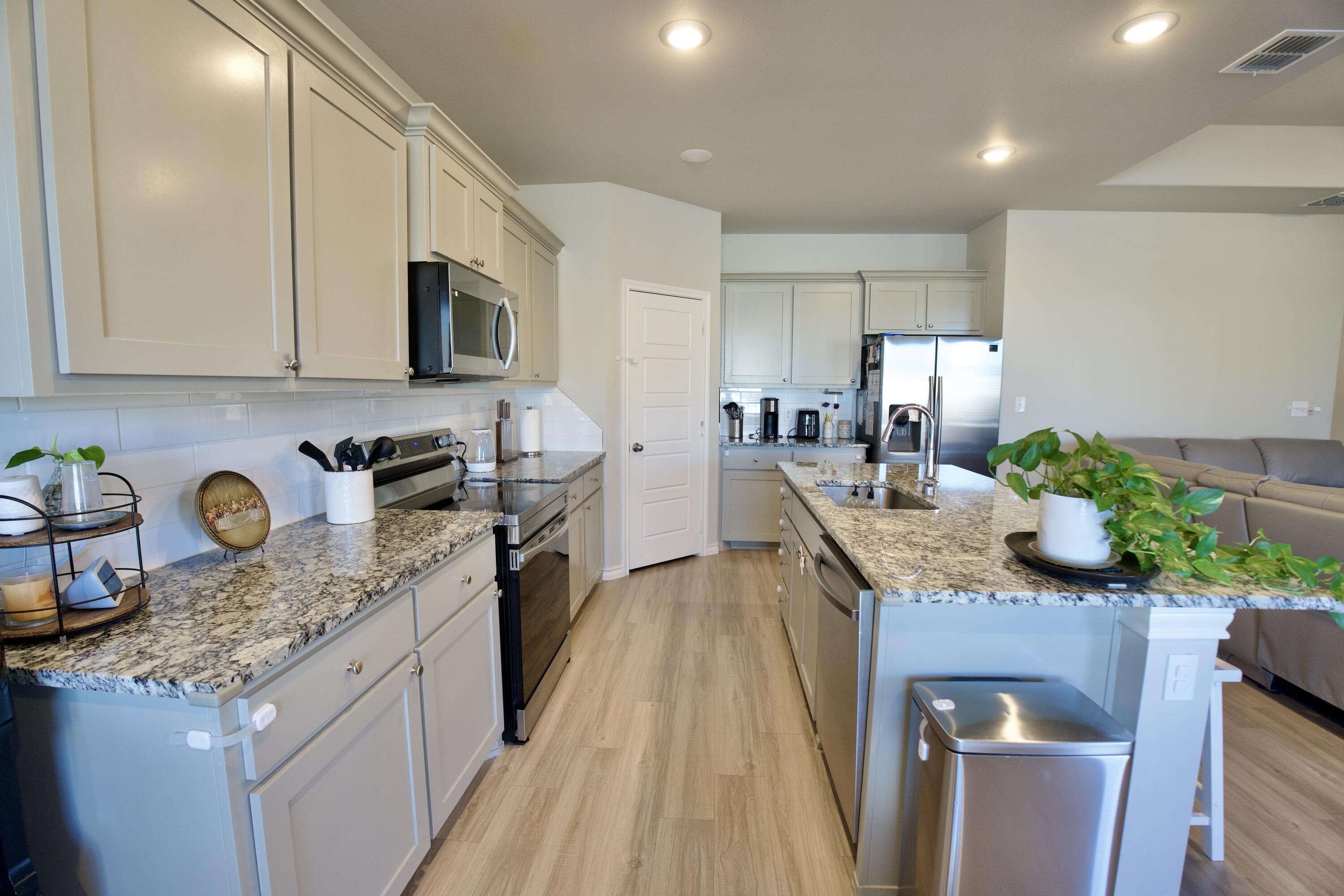 5801 Winfield Avenue Lubbock, TX 79407 - Photo 5 of 20 a kitchen with granite countertop kitchen island stainless steel appliances a sink a stove top oven a counter space and cabinets